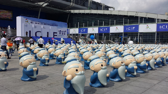 Dozens of cute Confucius cartoon statues stand in line near the entrance of the cultural fair hall.(from china culture)