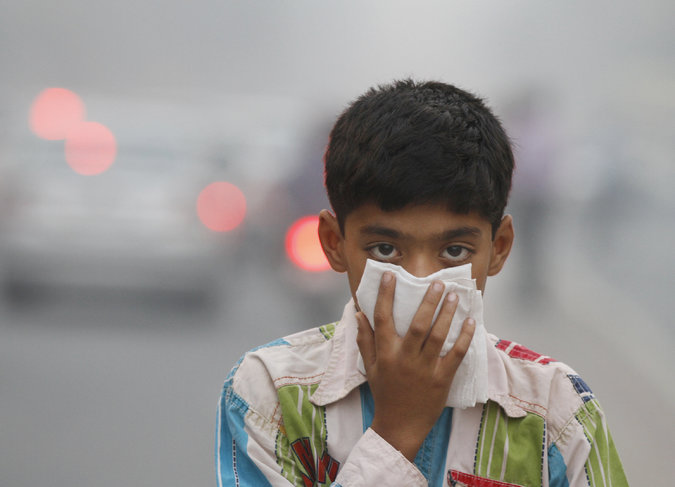 A child tries to protect himself from the air pollution in New Delhi. Credit Sanjeev Verma/Hindustan Times, via Getty Images