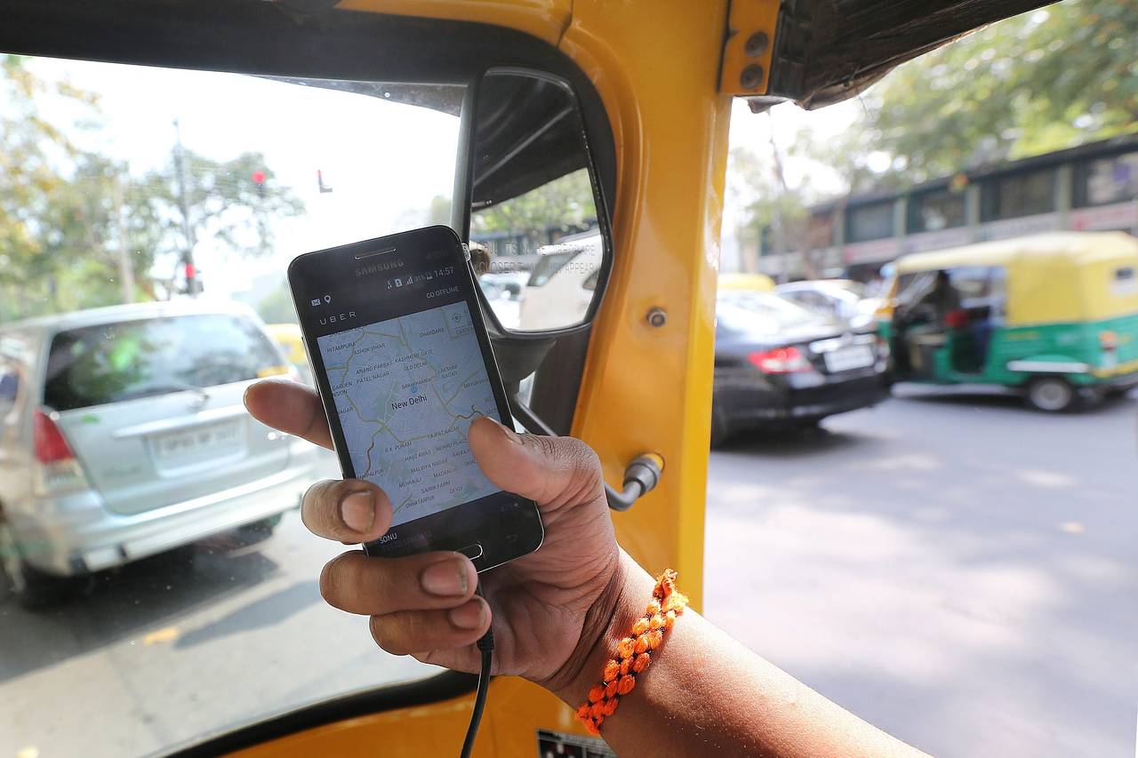 An auto-rickshaw driver opens the Uber app on his phone in New Delhi. India is Uber’s second-biggest market after the U.S. in terms of the number of cities in which it operates. PHOTO: EUROPEAN PRESSPHOTO AGENCY