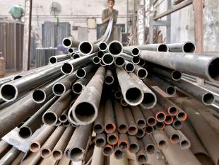 A worker stacks steel pipes in the western Indian city of Ahmedabad.