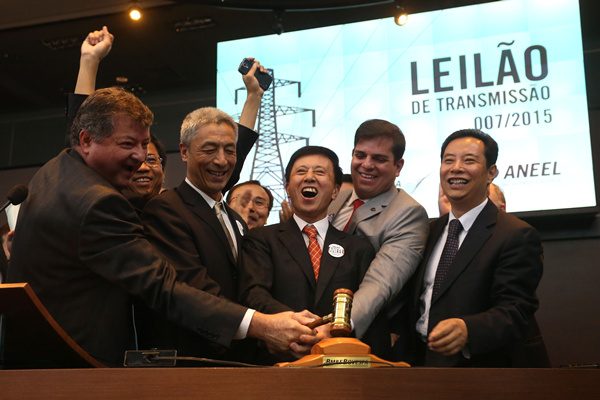 © Yang Qing (center), executive vice-president and deputy general manager of State Grid Corporation of China, celebrates after winning an auction for the procurement of the second transmission system of power generated by the Belo Monde hydroelectric dam at BM&FBovespa Stock Market in Sao Paulo, Brazil, on July 17. Rahel Patrasso
