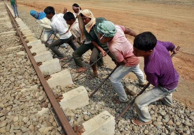 Labourers work at the installation site of a new railway track on the outskirts of Agartala, capital of Tripura February 25, 2015. REUTERS/Jayanta Dey/Files