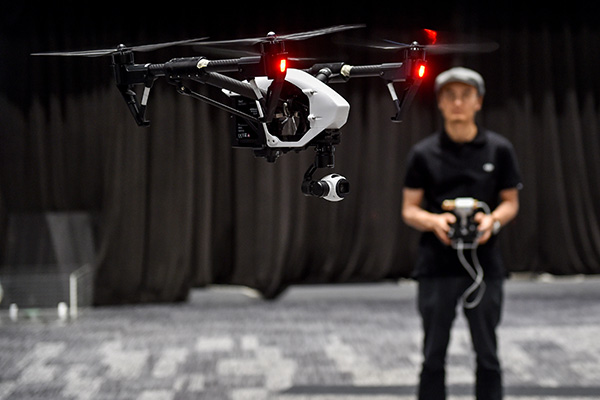 Wang Tao, founder and CEO of DJI Innovation Technology Co, operates a drone in Shenzhen, Guangdong province. The turnover of China's civil-use drone market is on track to soar to 2.3 billion yuan this year, according to an Analysys International estimate. [Photo/Xinhua]