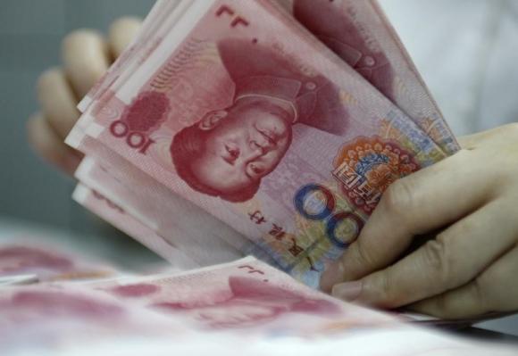An employee counts yuan banknotes at a bank in Huaibei, Anhui province.[Photo/Agencies]