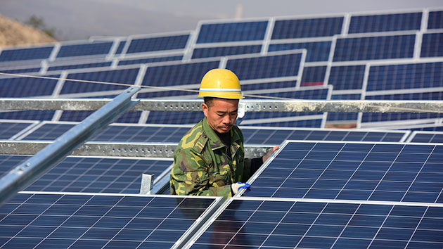A worker installs solar panels on November 17 in Yantai, Shandong Province, in China. Exclusivepix Media/Whitehotpix/ZUMA