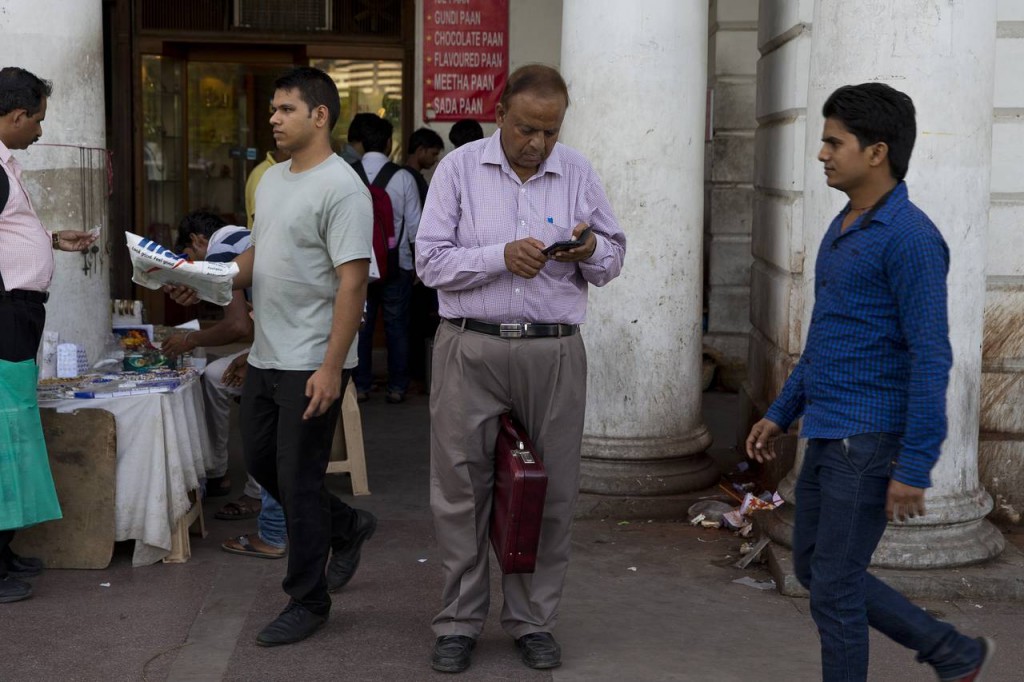An Indian man checks his mobile phone at the Connaught Place area of New Delhi. PHOTO: ASSOCIATED PRESS