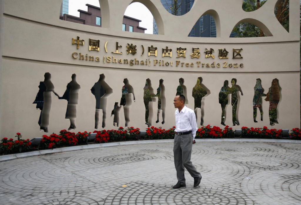 A man walks at the entrance of the new Shanghai Free Trade Zone in Pudong district, Shanghai September 29, 2013. China has formally announced detailed plans for a new free-trade zone (FTZ) in Shanghai, touted as the country's biggest potential economic reform since Deng Xiaoping used a similar zone in Shenzhen to pry open a closed economy to trade in 1978. In an announcement on Friday from the State Council, or cabinet, China said it will open up its largely sheltered services sector to foreign competition in the zone and use it as a testbed for bold financial reforms, including a convertible yuan and liberalized interest rates. Economists consider both areas key levers for restructuring the world's second-largest economy and putting it on a more sustainable growth path. REUTERS/Carlos Barria (CHINA - Tags: POLITICS BUSINESS)