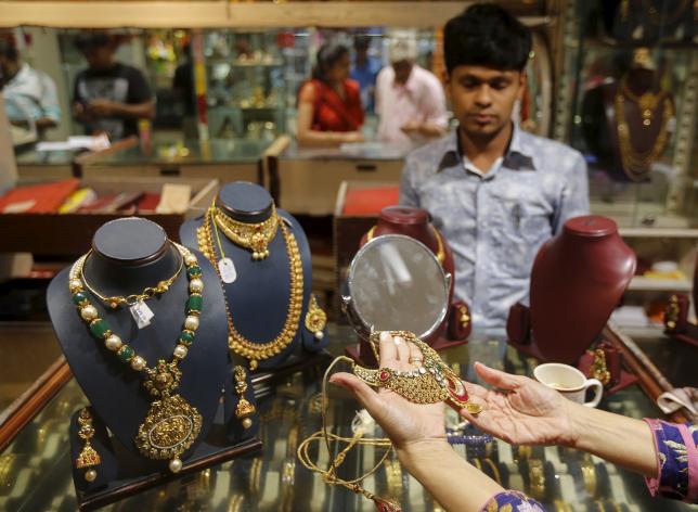 A customer tries a gold necklace at a jewellery showroom on the occasion of Dhanteras, a Hindu festival associated with Lakshmi, the goddess of wealth, at a market in Mumbai November 9, 2015. REUTERS/Shailesh Andrade/Files