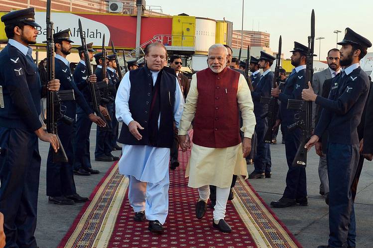 Pakistan Prime Minister Nawaz Sharif, left, and Indian Prime Minister Narendra Modi walk through a guard of honor in Lahore, Pakistan. Mr. Modi made a surprise visit to Pakistan to meet his counterpart weeks after the nuclear-armed rivals decided to restart high-level peace talks. PHOTO: PIB/AGENCE FRANCE-PRESSE/GETTY IMAGES