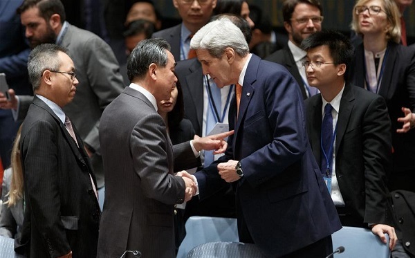 Chinese Foreign Minister Wang Yi talks with United States Secretary of State John Kerry prior to the United Nations Security Council meeting on Syria at the UN headquarters in New York, Dec. 18, 2015. © Xinhua