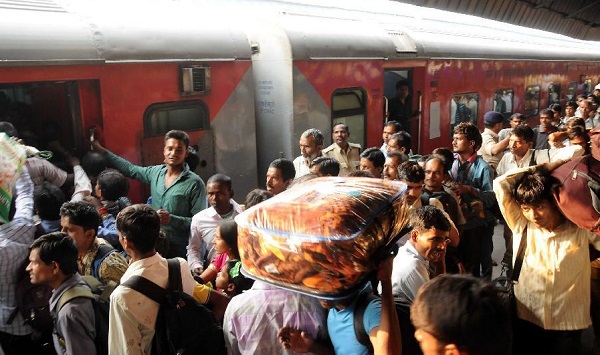 File Photo: Passengers try to board a train at the New Delhi Railway Station [Xinhua]