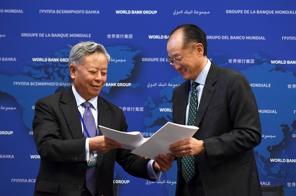 World Bank President Jim Yong Kim (R) and Asian Infrastructure Investment Bank (AIIB) President Jin Liqun exchange documents after signing the first co-financing framework agreement at the headquarters of World Bank in Washington D.C., the United States, April 13, 2016 [Xinhua]