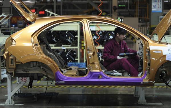 An employee works at a production line of an automobile factory in Hefei, Anhui province, China. File Photo